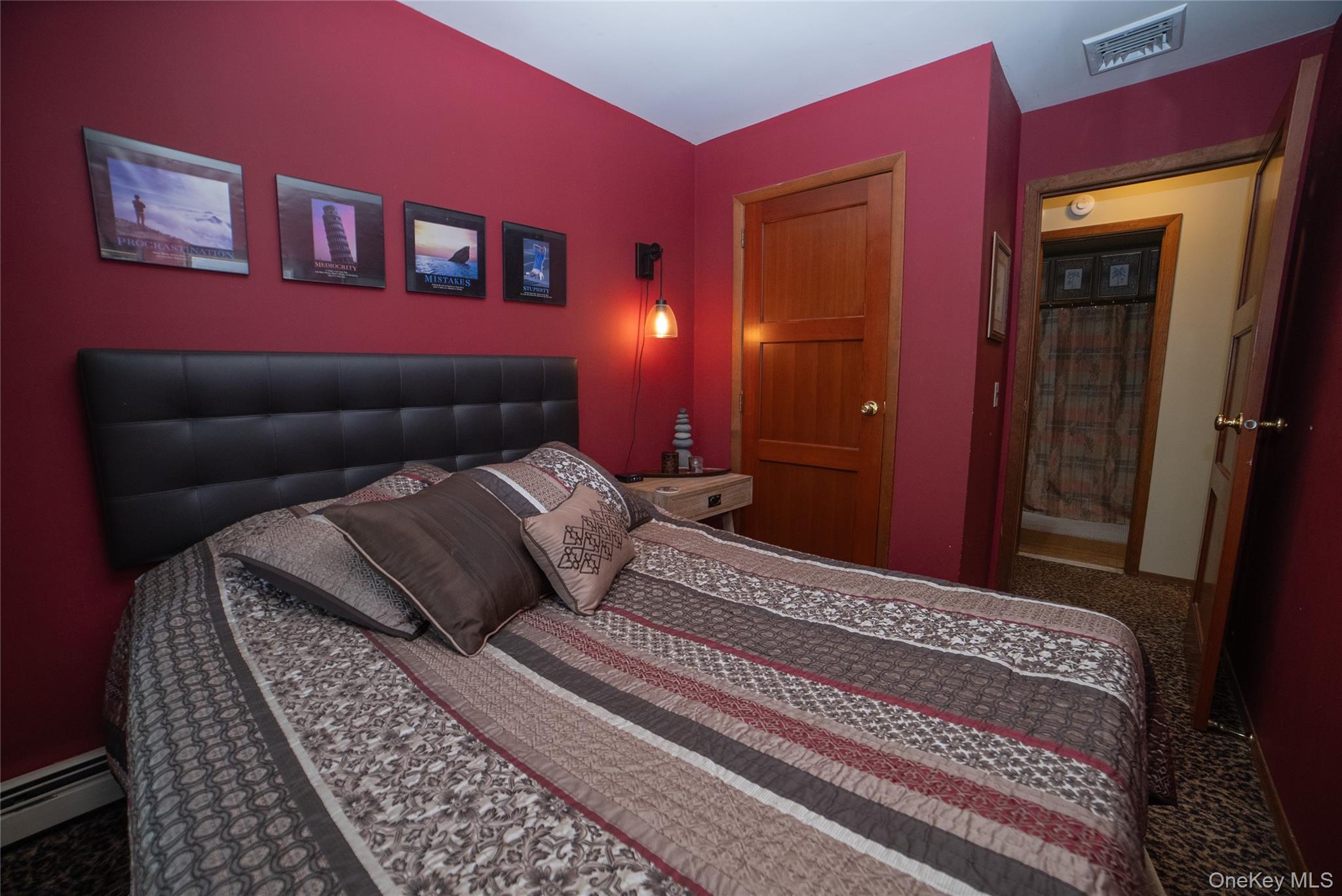 30 Long Bow Road Wading River, NY 11792 - Photo 10 of 19 a bedroom with a bed and a lamp on dresser