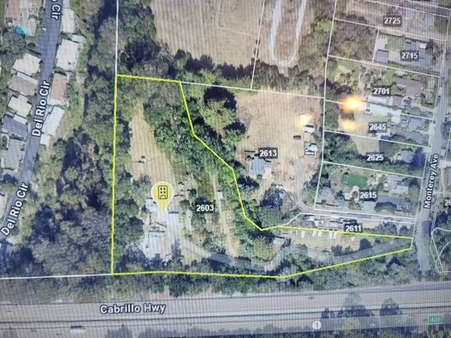 a view of a wooden house with a yard and large trees