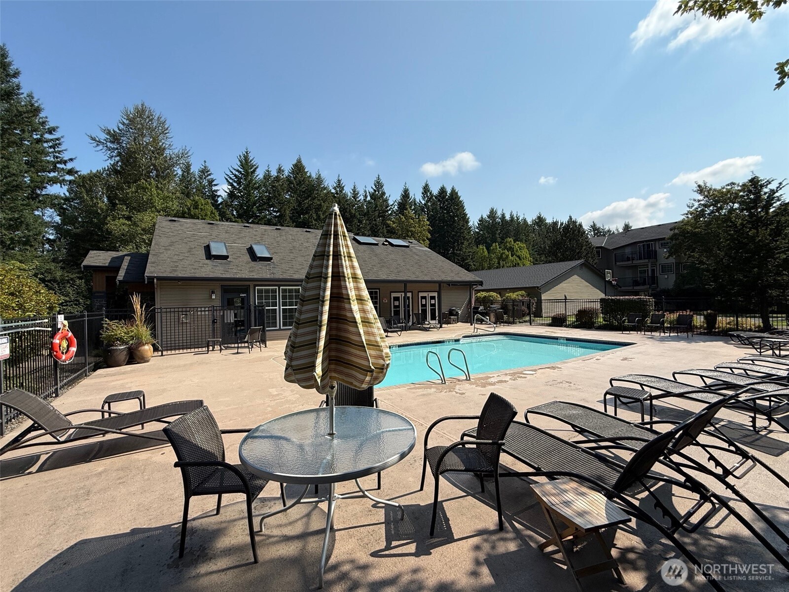 25025 Southeast Klahanie Boulevard, Unit D202 Issaquah, WA 98029 - Photo 16 of 23 a view of a patio with table and chairs with wooden floor and fence