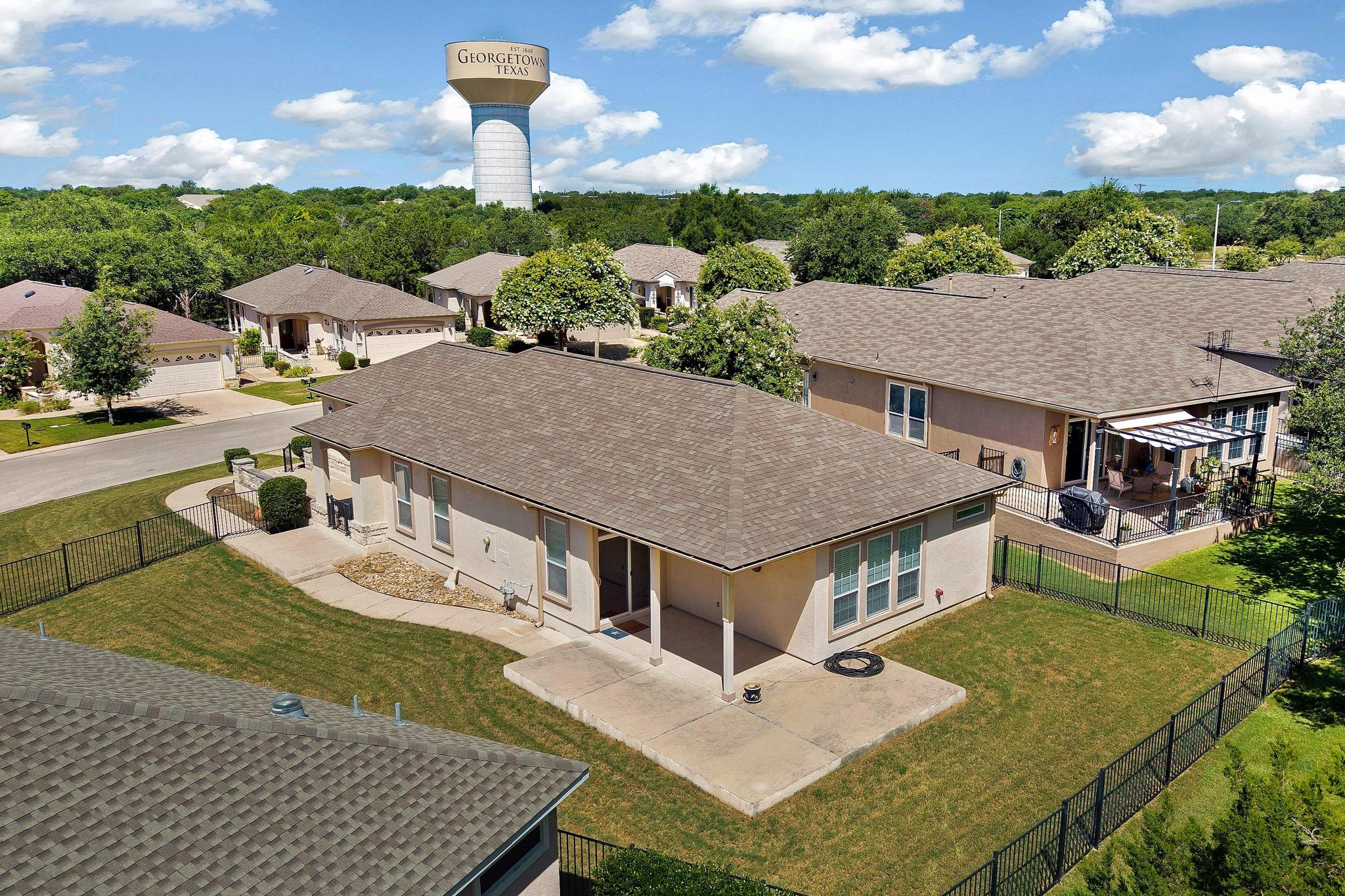 520 Mill Pond Path Georgetown, TX 78633 - Photo 33 of 38 An aerial perspective reveals a cozy home, nestled among lush greenery, featuring a welcoming covered patio.