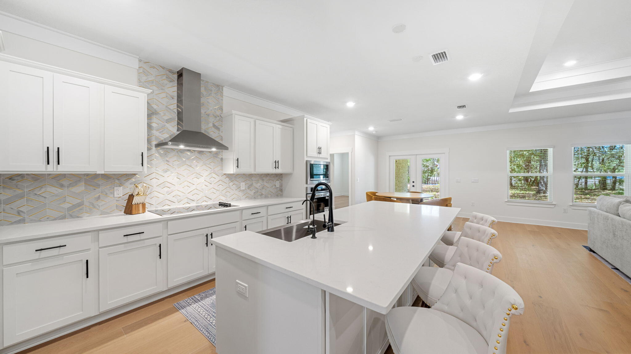 769 Old Ferry Road Santa Rosa Beach, FL 32459 - Photo 13 of 67 a kitchen with stainless steel appliances a sink a stove a refrigerator and white cabinets with wooden floor