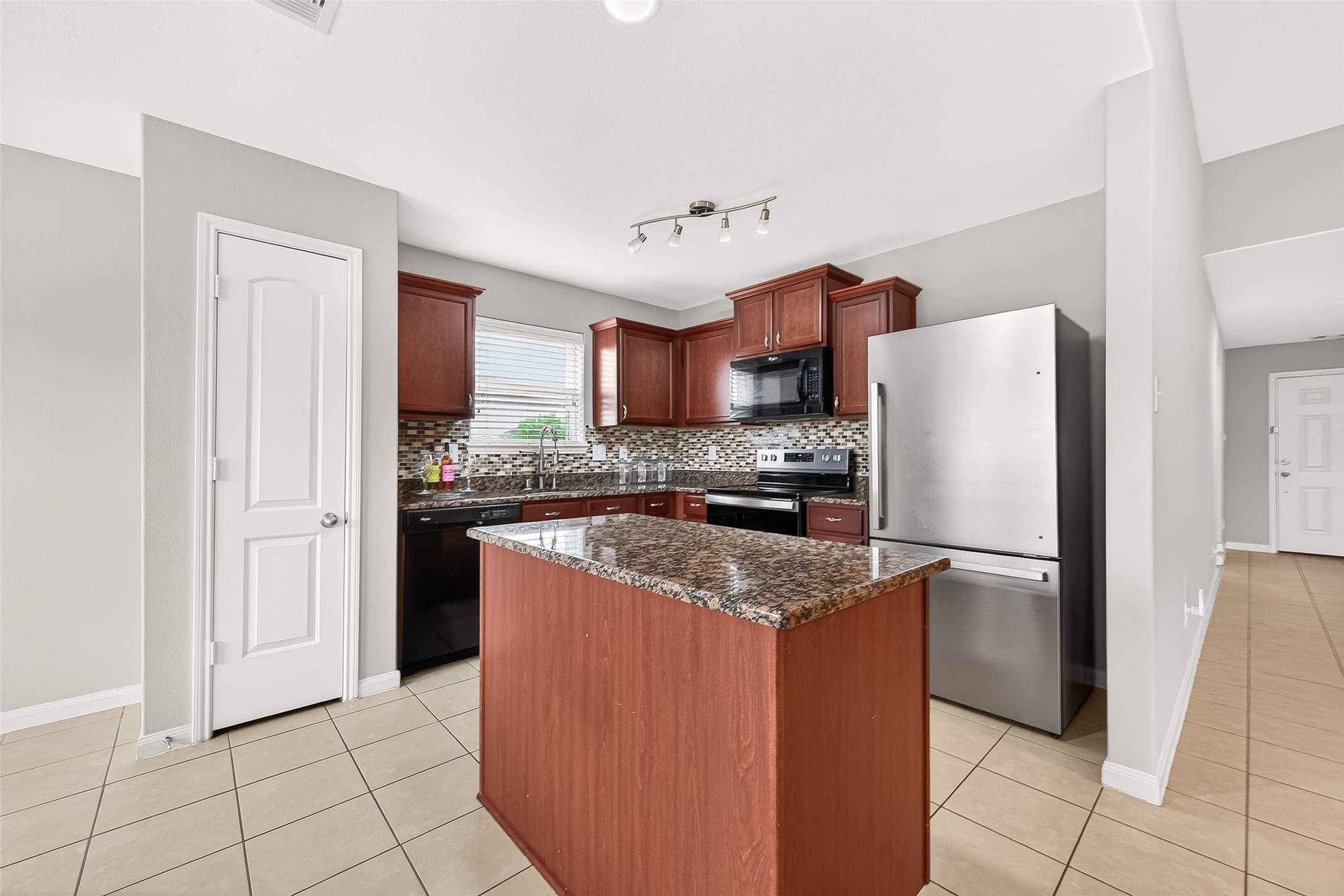 2314 Seabourne Trails Road Rosenberg, TX 77469 - Photo 8 of 38 Spacious kitchen with granite counters, modern backsplash, tile throughout, along with all appliances. Lots of natural light from kitchen window, dining room window & living room.