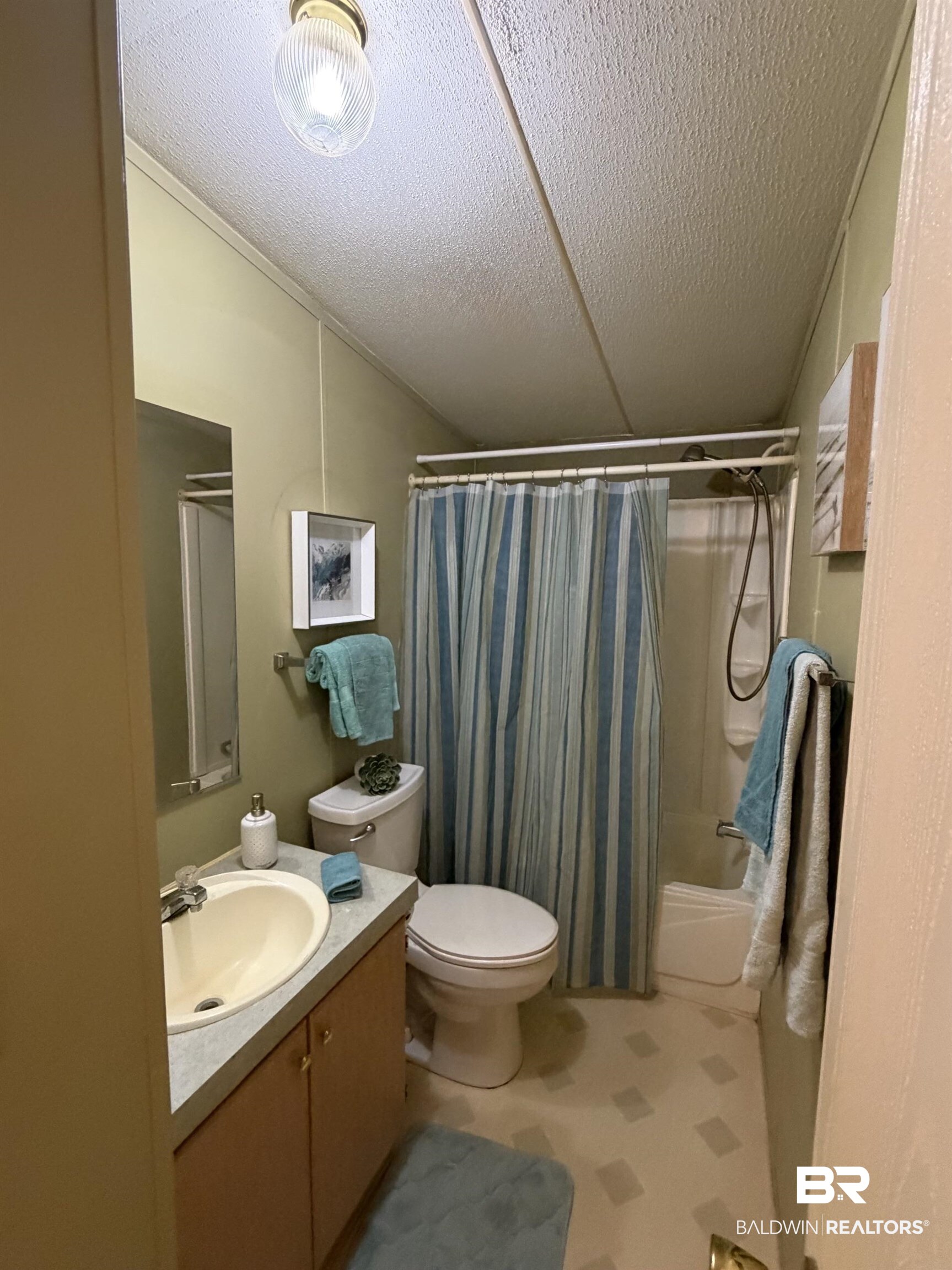 1125 Ridgewood Drive Lillian, AL 36549 - Photo 13 of 36 Bathroom featuring a single vanity, integrated sink, light-toned cabinetry, and a full-size bathtub with shower