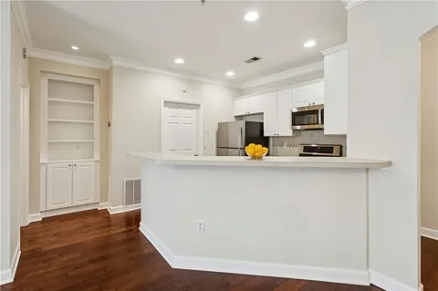 a view of kitchen with wooden floor and electronic appliances