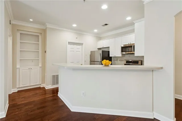a view of kitchen with wooden floor and electronic appliances