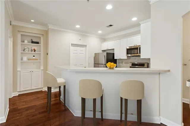 a kitchen with table chairs refrigerator and microwave