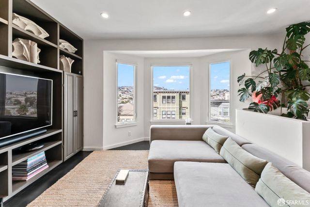 a living room with furniture a window and a flat screen tv