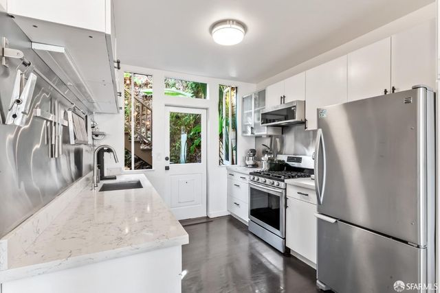 a kitchen with granite countertop a refrigerator stove and oven