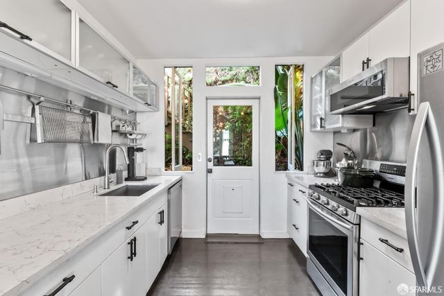 a kitchen with stainless steel appliances granite countertop a sink stove and cabinets