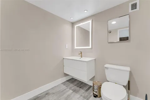 a bathroom with a toilet sink and mirror