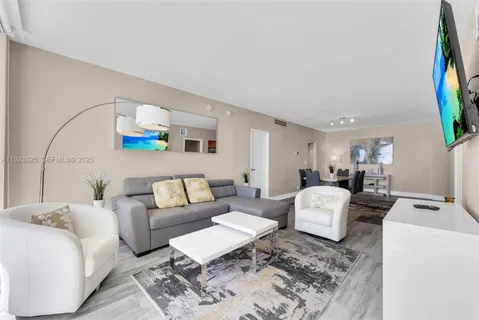 a living room with furniture a flat screen tv and a window