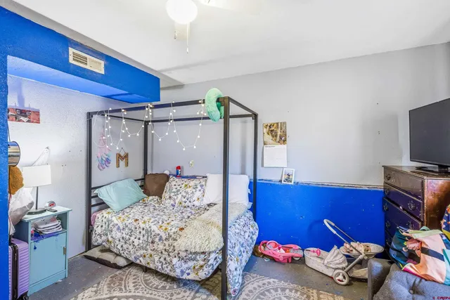 a bedroom with furniture and a flat screen tv