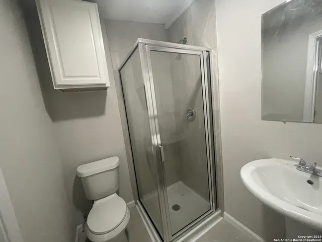 a bathroom with a shower a toilet and a sink