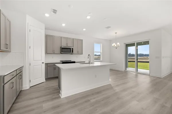 a large kitchen with stainless steel appliances granite countertop a stove a sink and a refrigerator