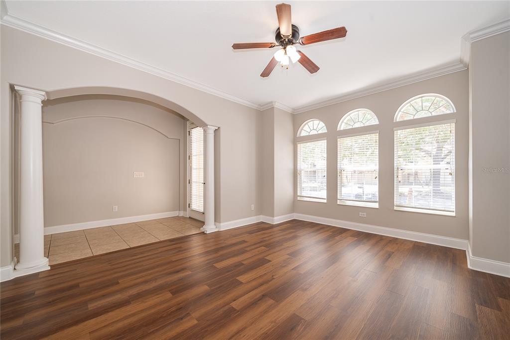 6825 Dolce Way Orlando, FL 32819 - Photo 11 of 40 a view of an empty room with wooden floor and a window