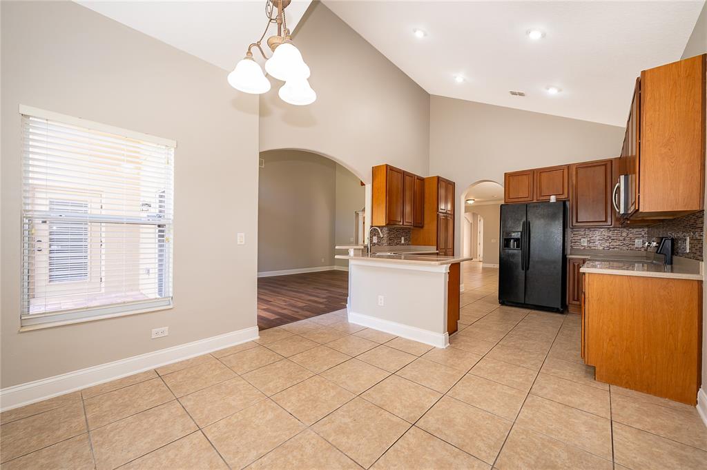 6825 Dolce Way Orlando, FL 32819 - Photo 18 of 40 a kitchen with stainless steel appliances granite countertop a refrigerator and a stove top oven