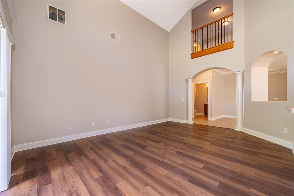 6825 Dolce Way Orlando, FL 32819 - Photo 22 of 40 a view of an empty room with wooden floor and a window