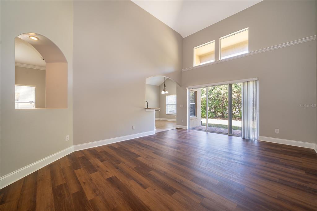6825 Dolce Way Orlando, FL 32819 - Photo 24 of 40 a view of an empty room with wooden floor and a window