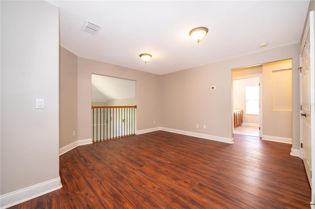 6825 Dolce Way Orlando, FL 32819 - Photo 32 of 40 a view of an empty room with wooden floor and a window