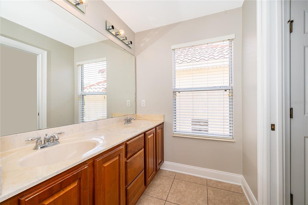 6825 Dolce Way Orlando, FL 32819 - Photo 36 of 40 a bathroom with a sink a vanity and a mirror