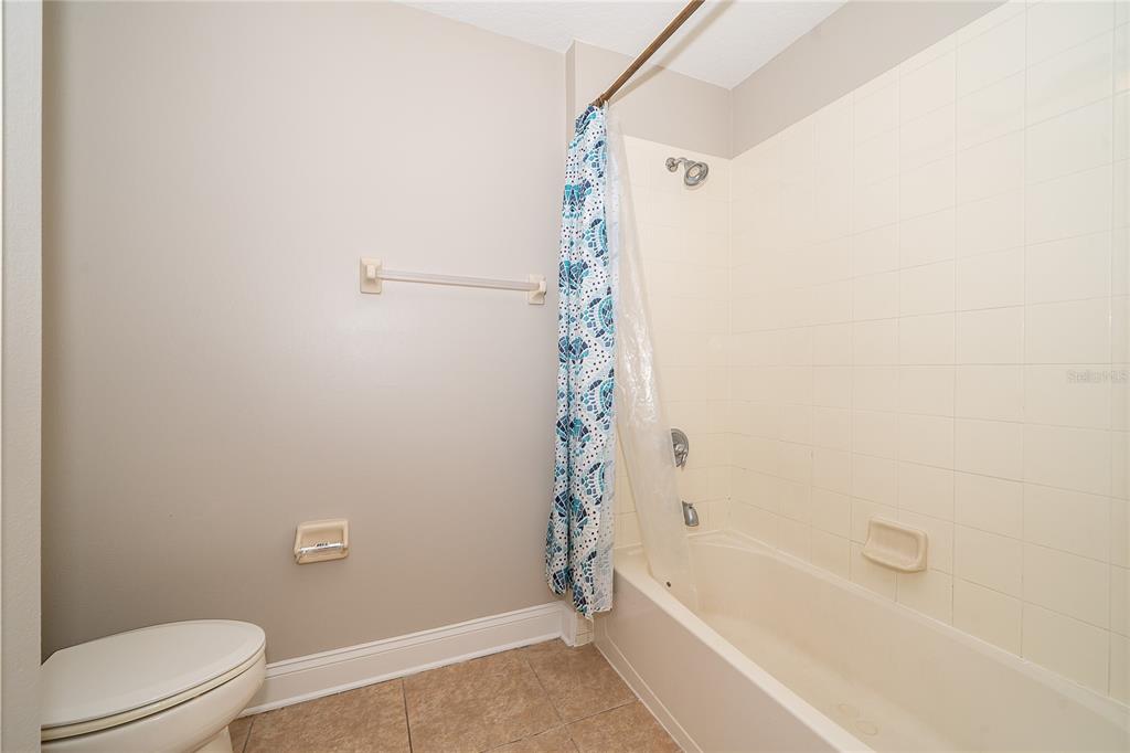 6825 Dolce Way Orlando, FL 32819 - Photo 37 of 40 a bathroom with a bathtub and a toilet