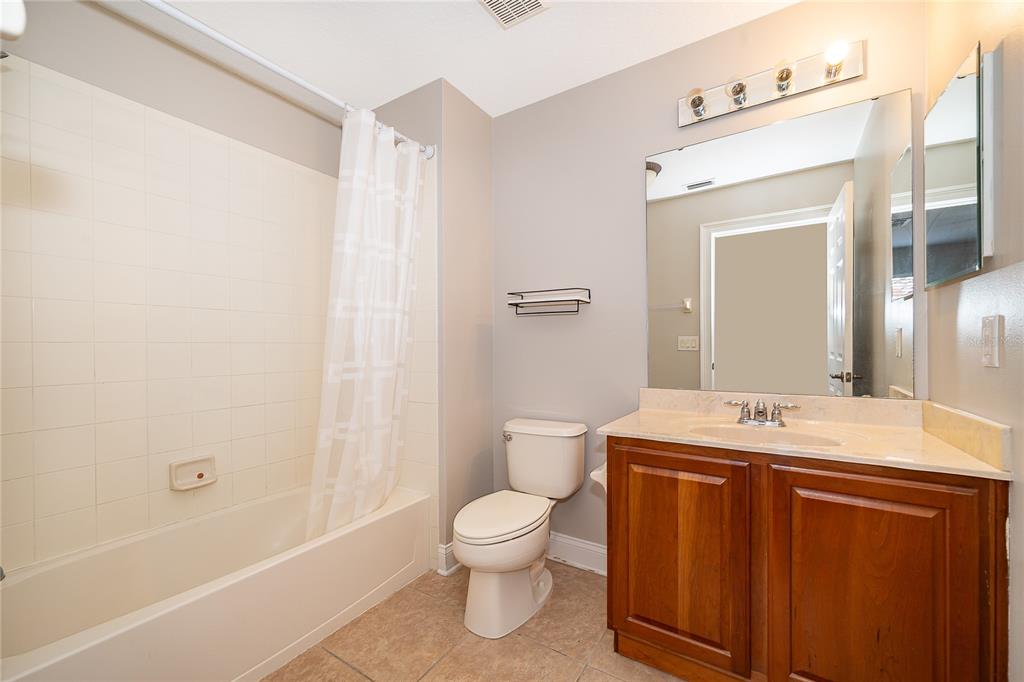 6825 Dolce Way Orlando, FL 32819 - Photo 40 of 40 a bathroom with a granite countertop sink toilet a large mirror a bathtub and shower
