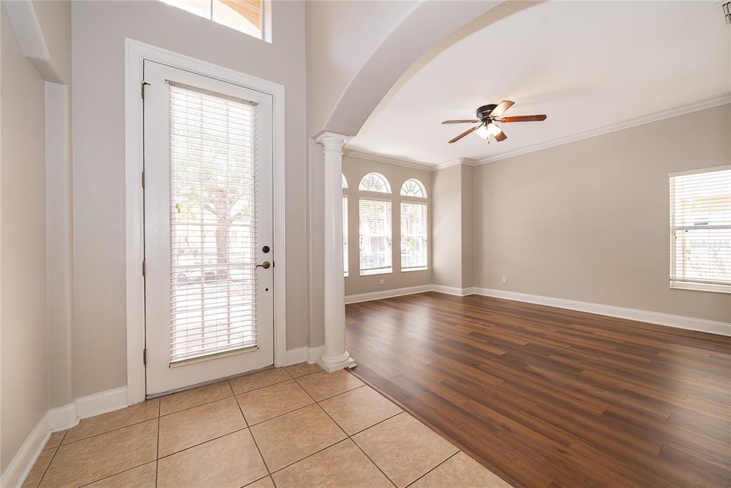 6825 Dolce Way Orlando, FL 32819 - Photo 10 of 40 a view of an empty room with a window and wooden floor