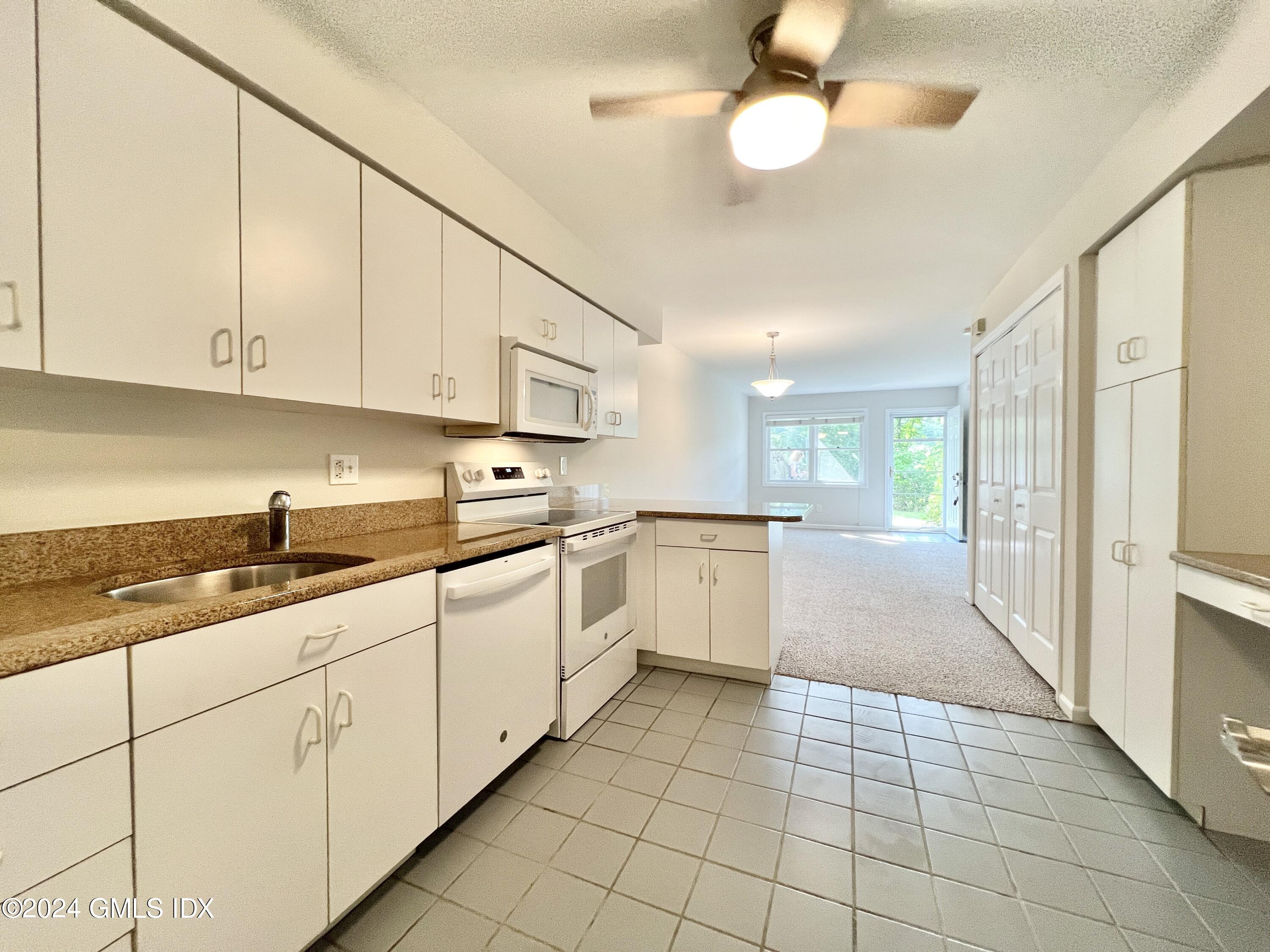 351 Pemberwick Road, Unit 206 Greenwich, CT 06831 - Photo 11 of 25 a kitchen with a sink window and cabinets