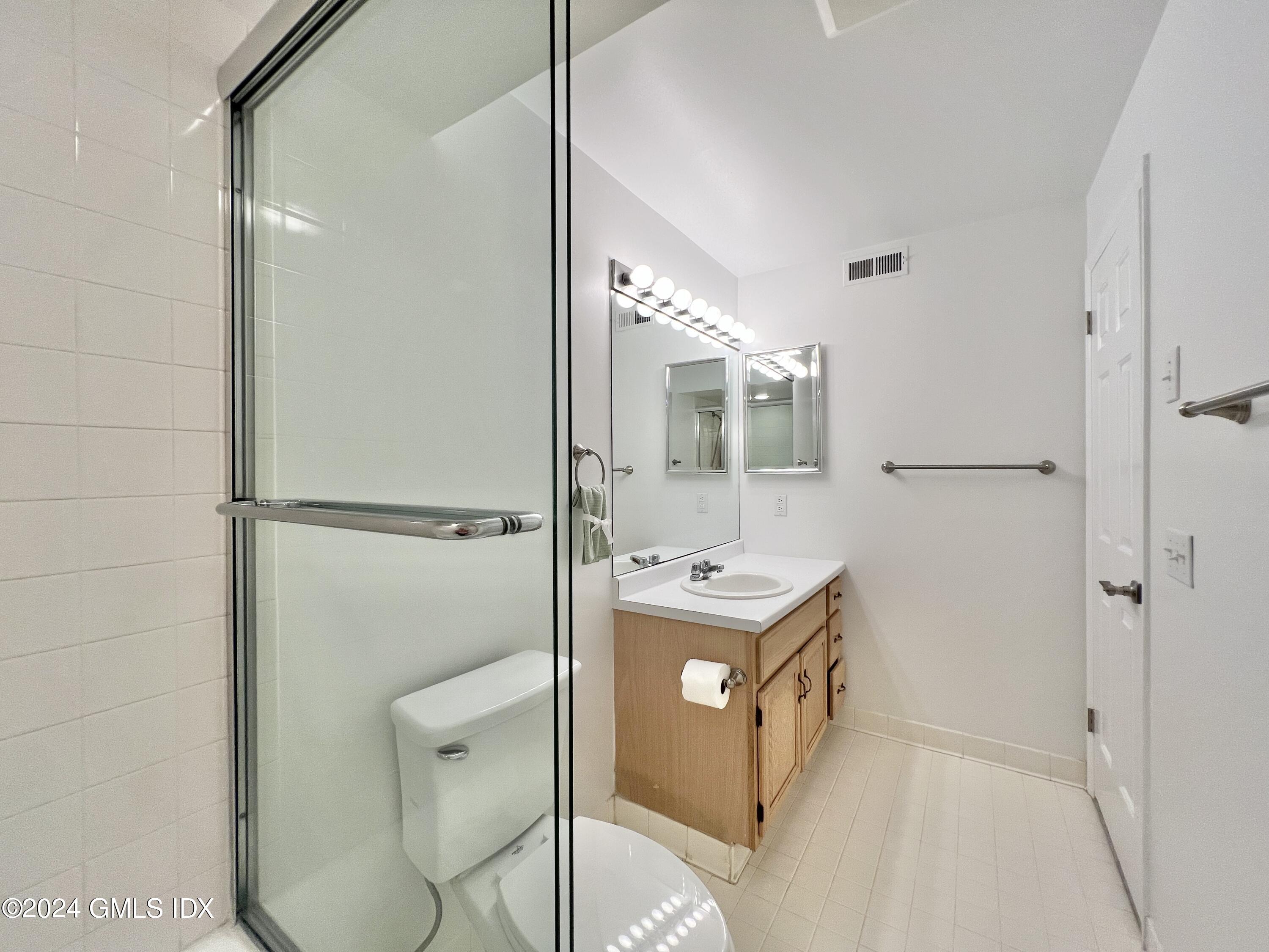 351 Pemberwick Road, Unit 206 Greenwich, CT 06831 - Photo 18 of 25 a bathroom with a granite countertop sink a toilet and shower