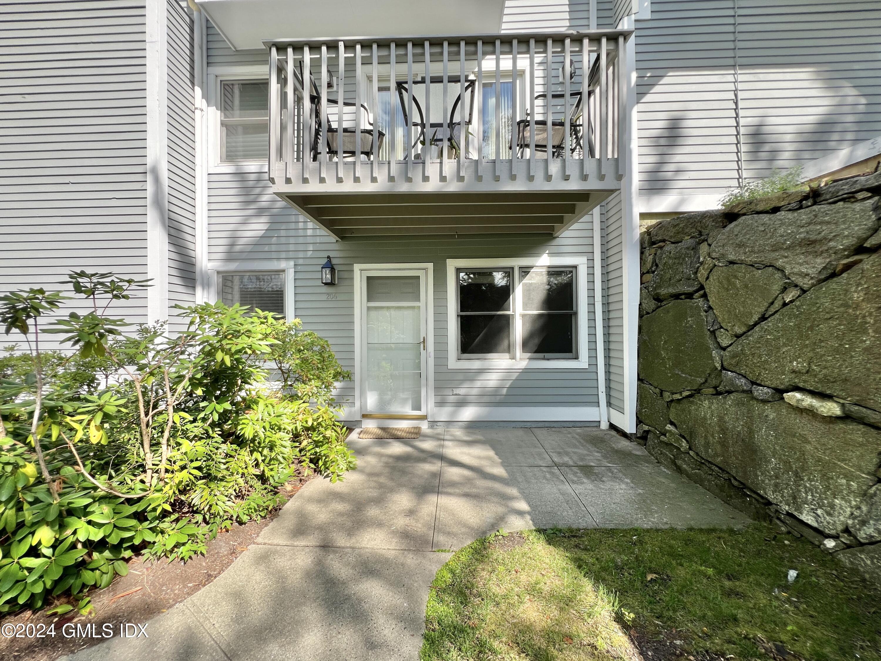 351 Pemberwick Road, Unit 206 Greenwich, CT 06831 - Photo 4 of 25 a front view of a house with garden