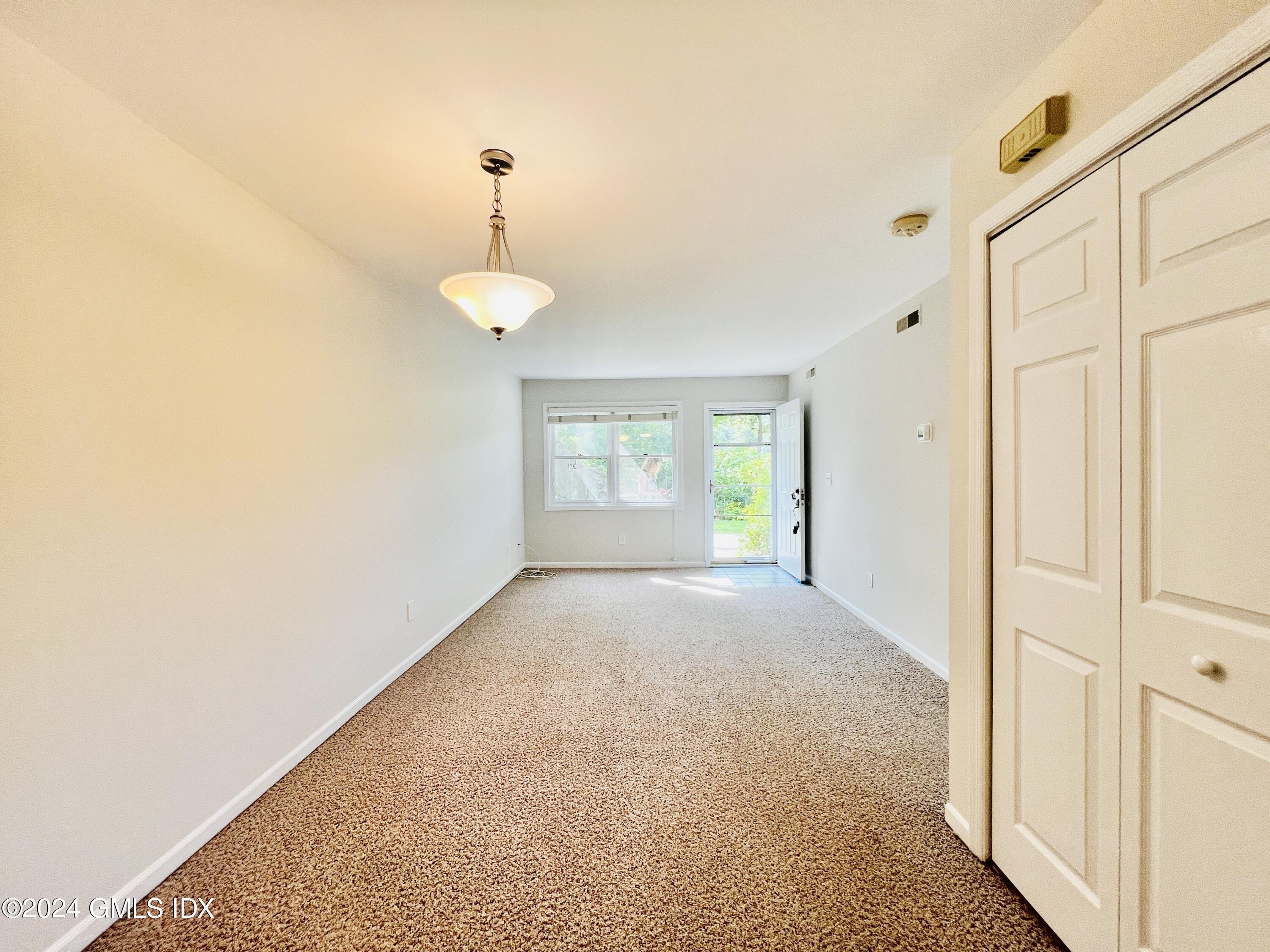 351 Pemberwick Road, Unit 206 Greenwich, CT 06831 - Photo 8 of 25 a view of a room with a windows and chandelier