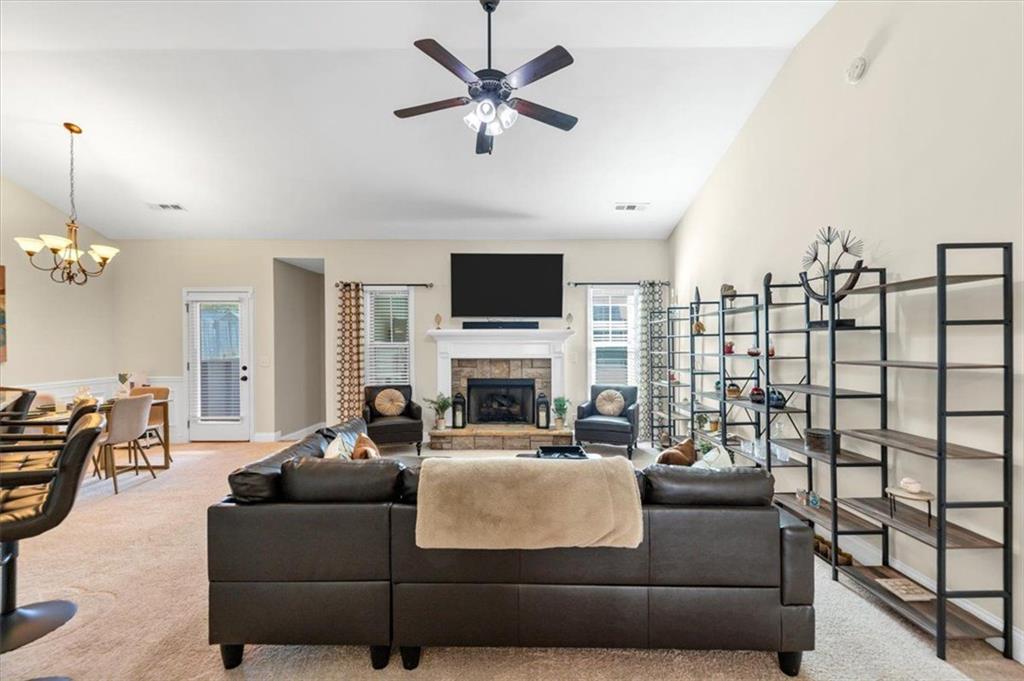 229 Summer Gate Lane Villa Rica, GA 30180 - Photo 12 of 28 a living room with furniture a fireplace and a chandelier