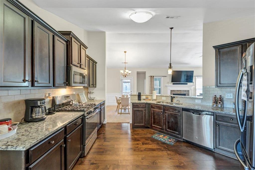 229 Summer Gate Lane Villa Rica, GA 30180 - Photo 17 of 28 a kitchen with stainless steel appliances granite countertop a sink a stove and a wooden floors