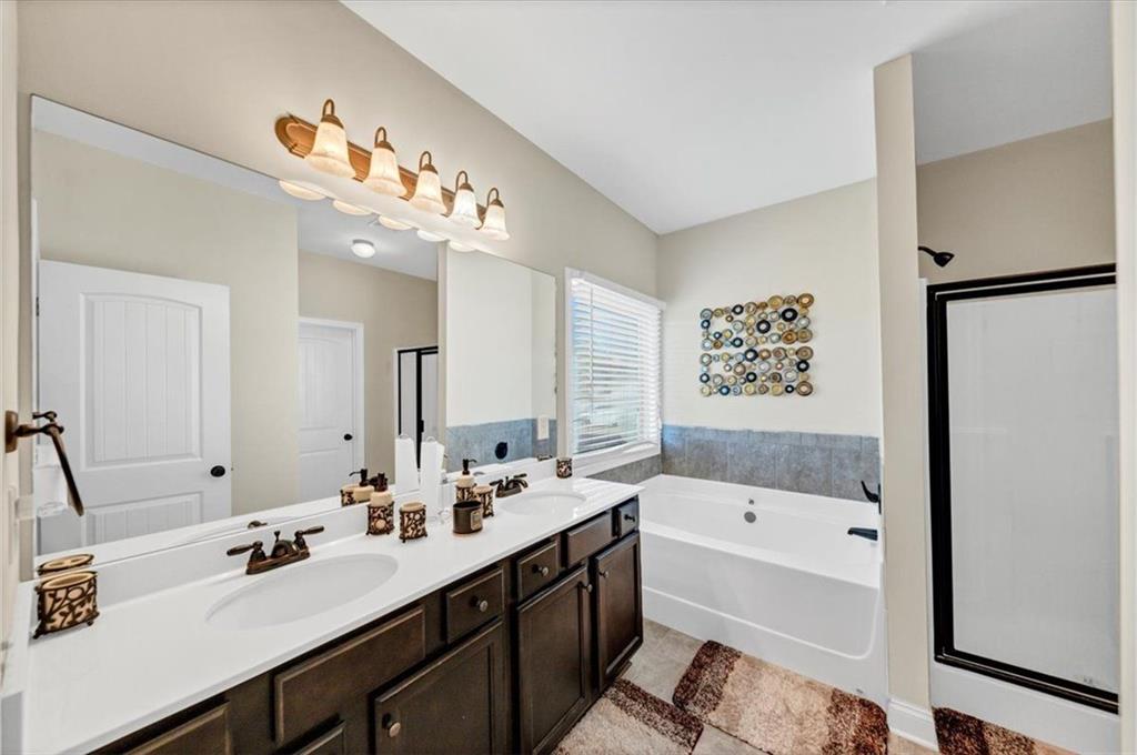 229 Summer Gate Lane Villa Rica, GA 30180 - Photo 21 of 28 a bathroom with a double vanity sink mirror double vanity tub and shower