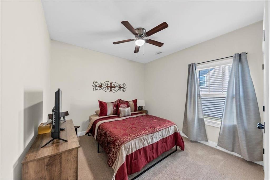 229 Summer Gate Lane Villa Rica, GA 30180 - Photo 7 of 28 a bedroom with a bed and a chandelier