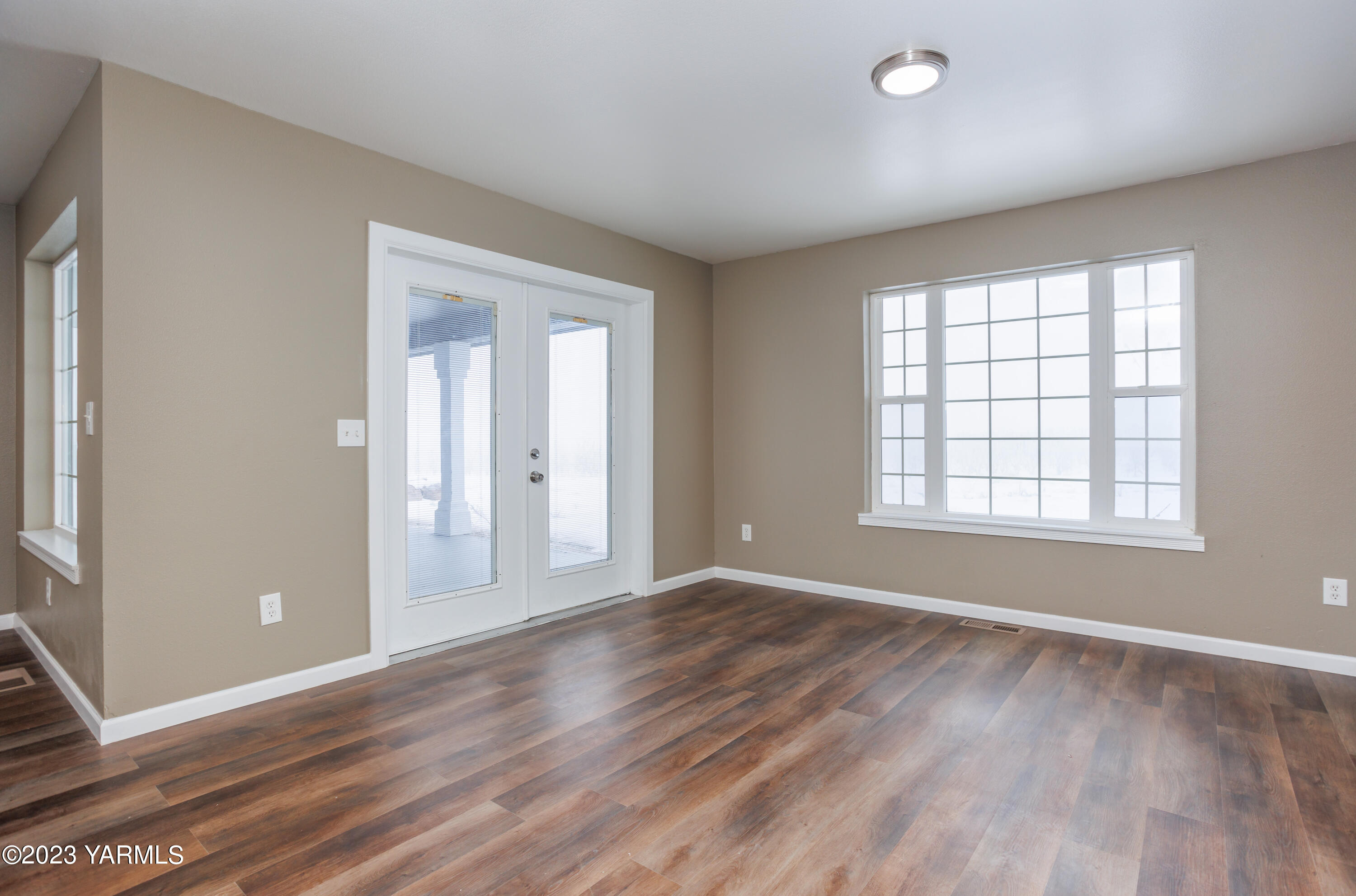 361 Puterbaugh Road Grandview, WA 98930 - Photo 11 of 47 a view of an empty room with wooden floor and a window