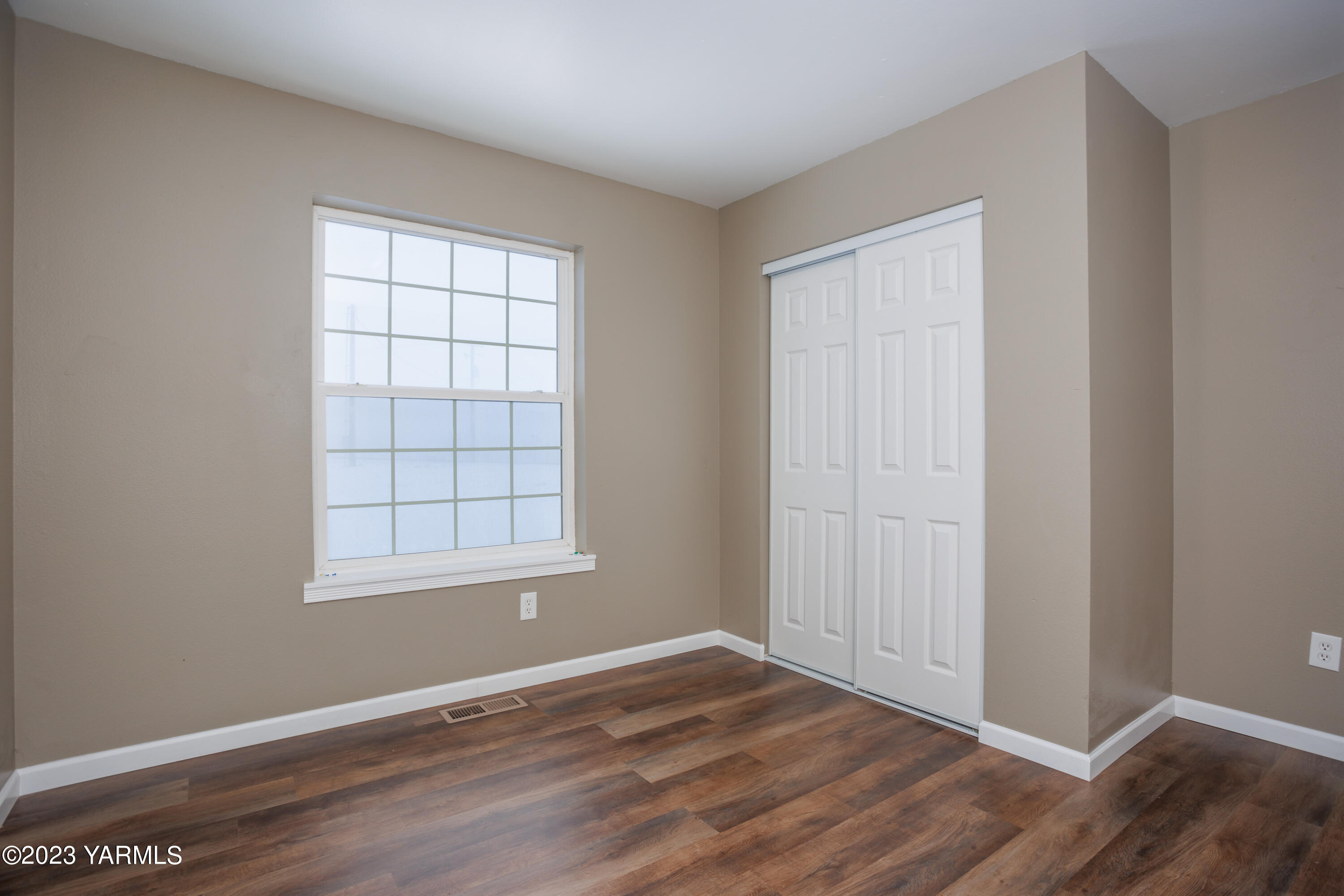 361 Puterbaugh Road Grandview, WA 98930 - Photo 15 of 47 an empty room with wooden floor and windows