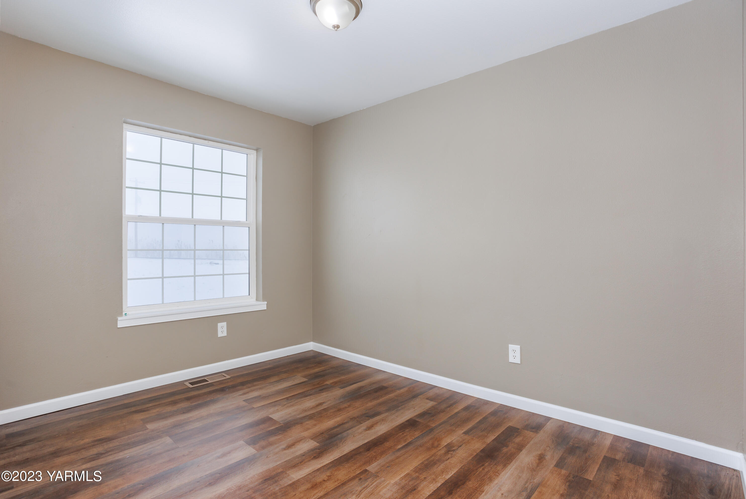 361 Puterbaugh Road Grandview, WA 98930 - Photo 20 of 47 an empty room with wooden floor and windows