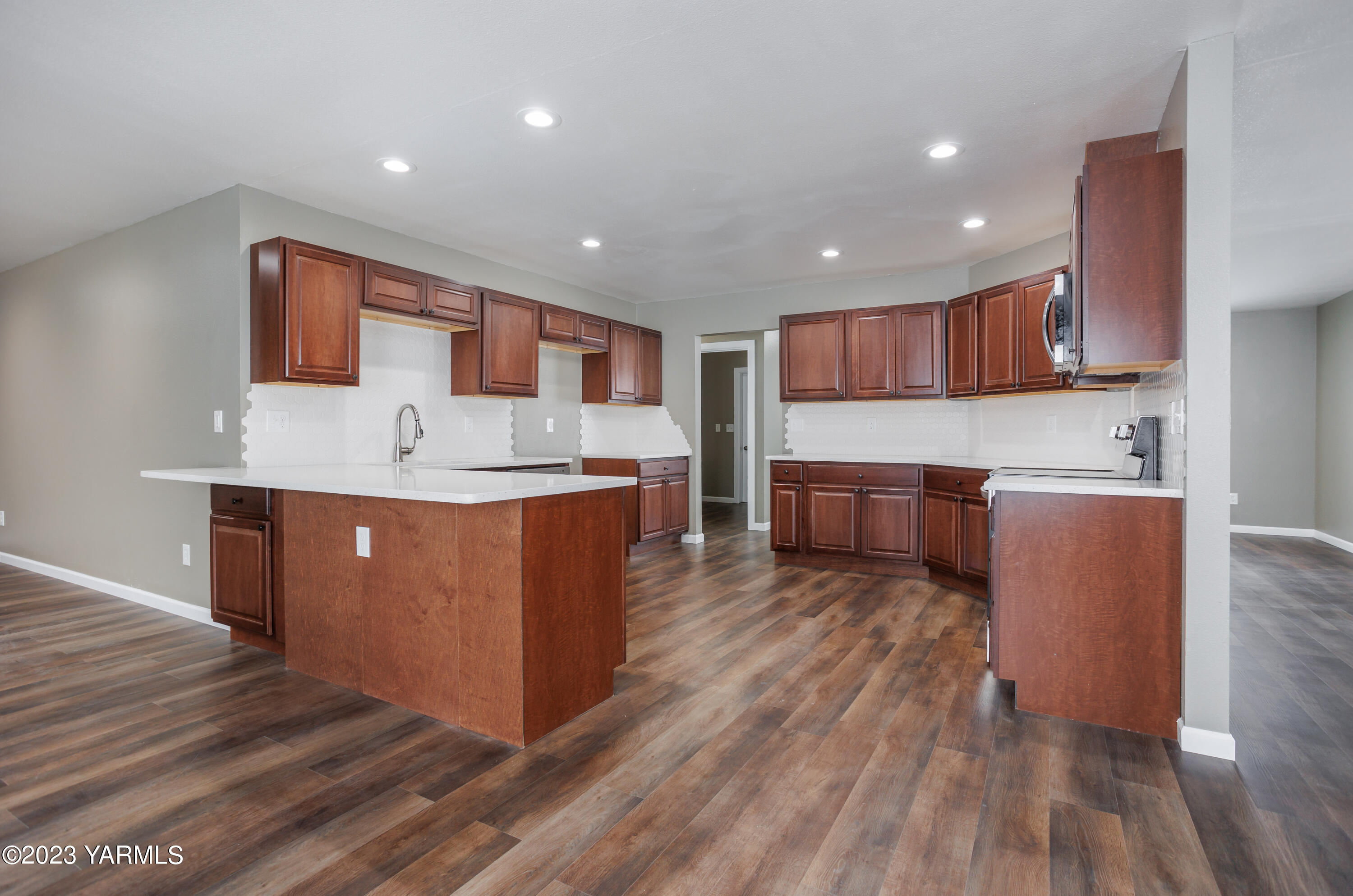 361 Puterbaugh Road Grandview, WA 98930 - Photo 2 of 47 a kitchen with stainless steel appliances granite countertop a sink a stove a refrigerator cabinets and wooden floor