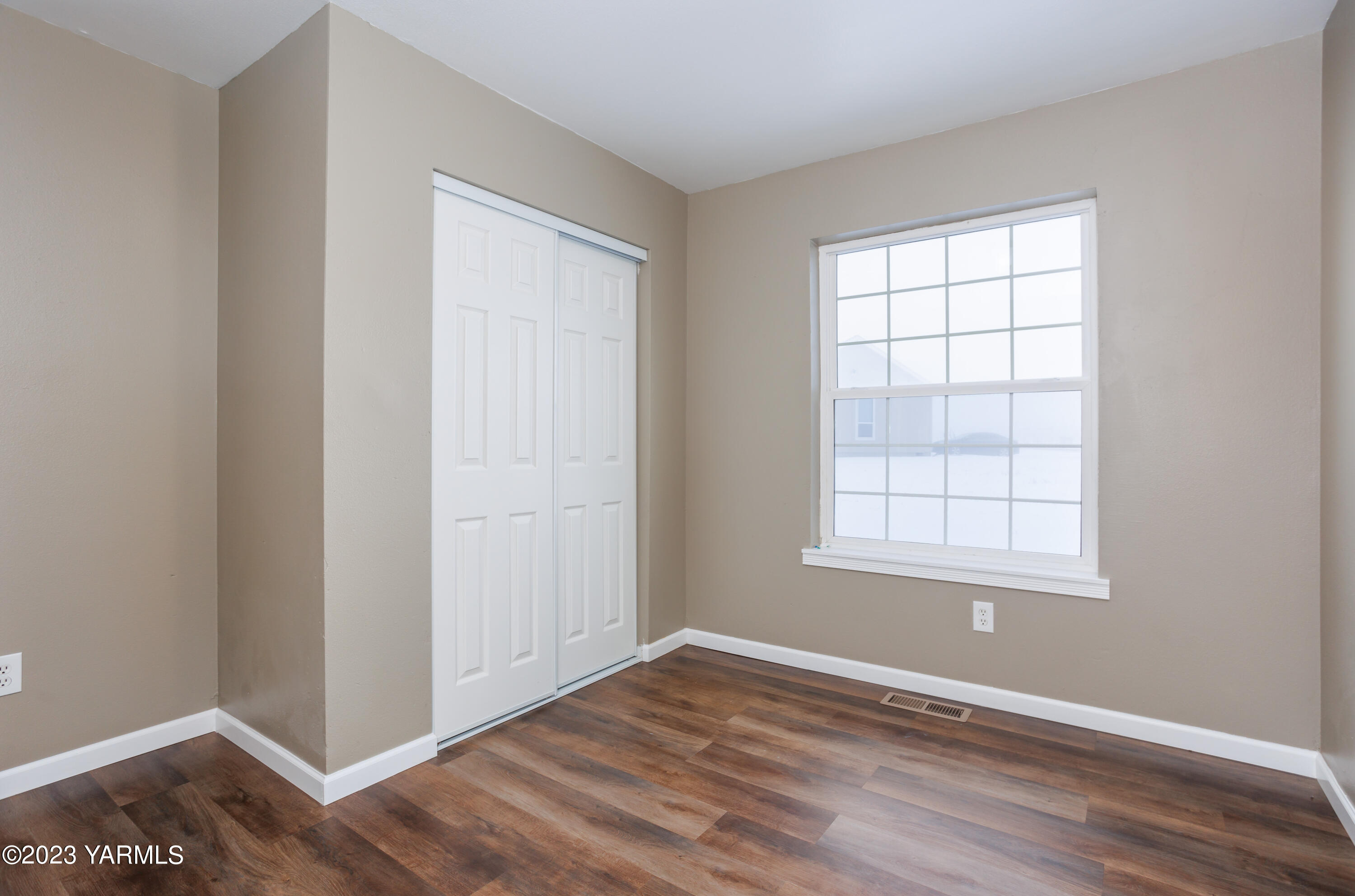 361 Puterbaugh Road Grandview, WA 98930 - Photo 21 of 47 an empty room with wooden floor and windows