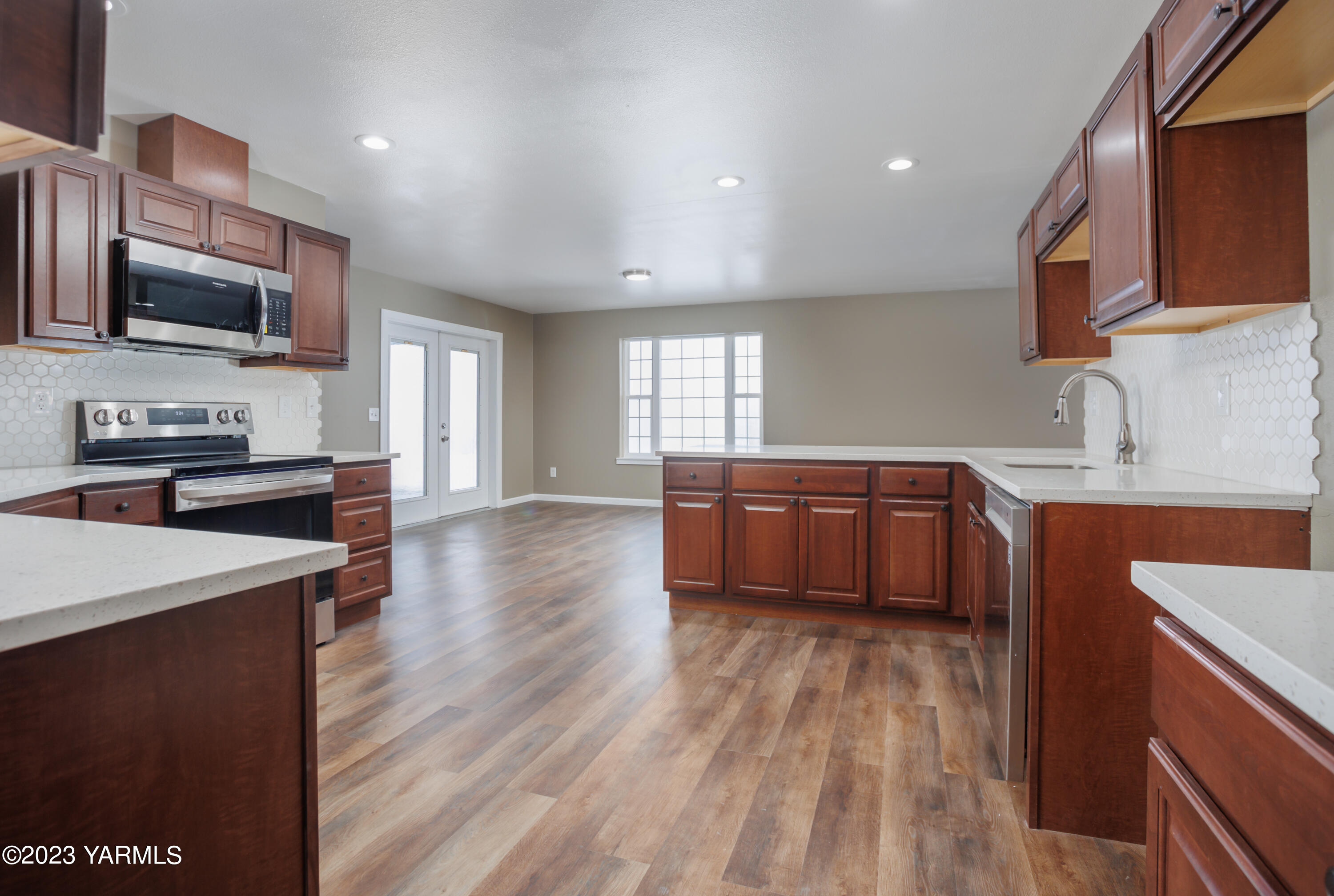 361 Puterbaugh Road Grandview, WA 98930 - Photo 3 of 47 a kitchen with stainless steel appliances wooden floors and a view of living room