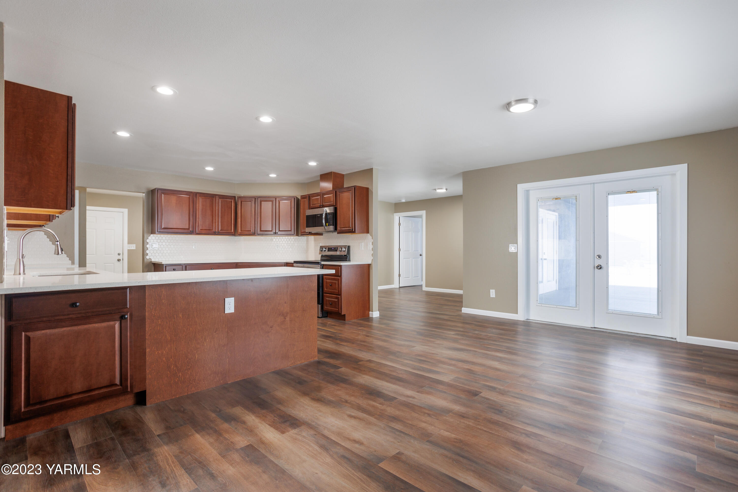 361 Puterbaugh Road Grandview, WA 98930 - Photo 5 of 47 a kitchen with stainless steel appliances granite countertop a refrigerator a sink dishwasher and a oven with wooden floor