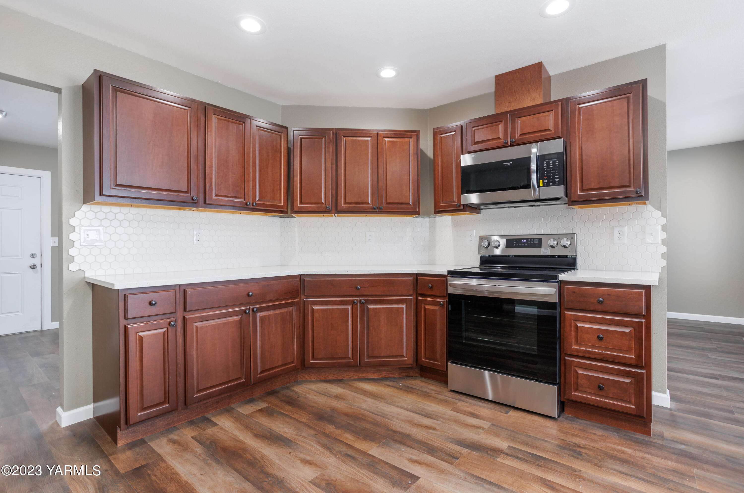 361 Puterbaugh Road Grandview, WA 98930 - Photo 7 of 47 a kitchen with stainless steel appliances granite countertop a stove top oven a sink dishwasher and a microwave oven on the wooden floor