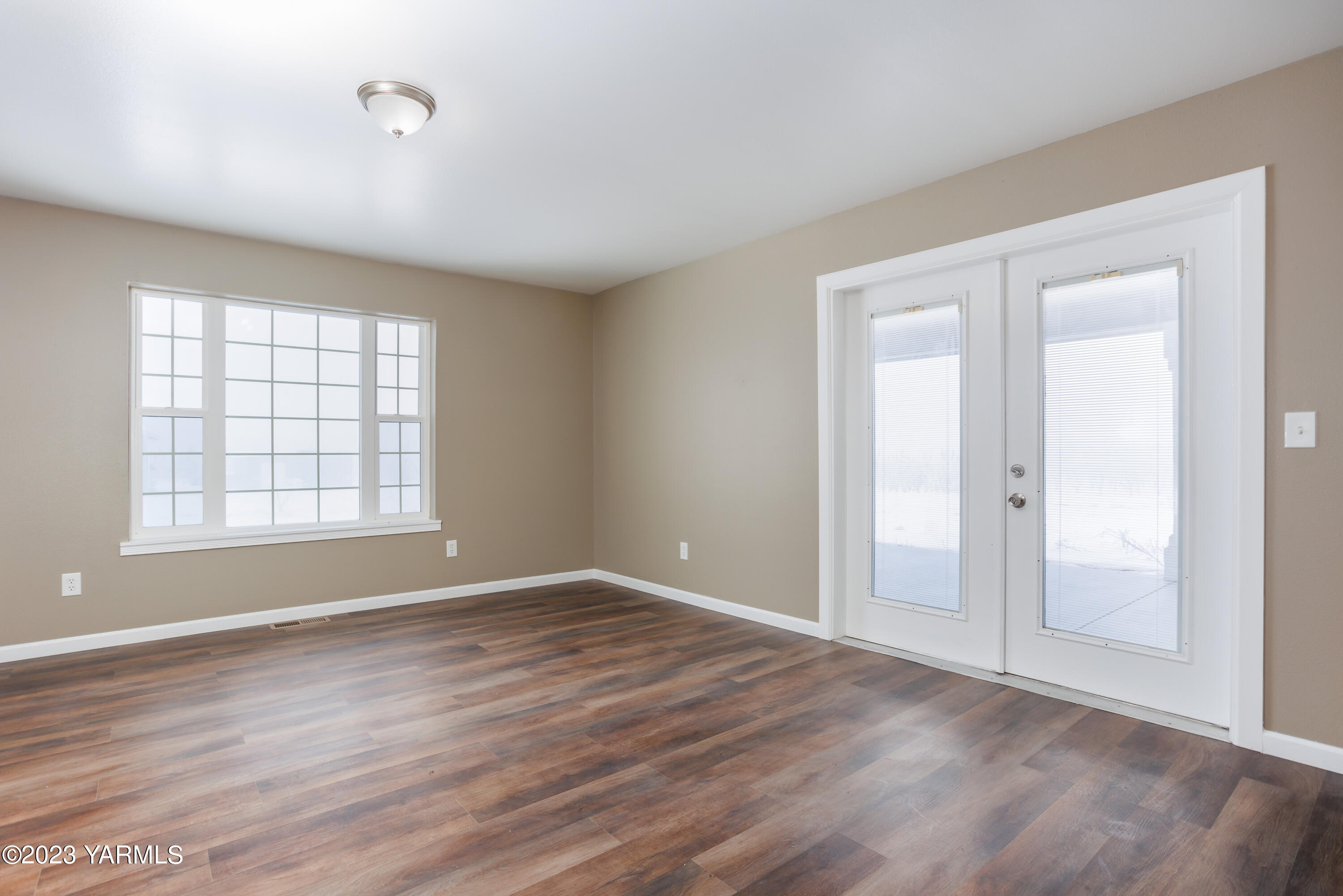 361 Puterbaugh Road Grandview, WA 98930 - Photo 8 of 47 a view of an empty room with wooden floor and a window