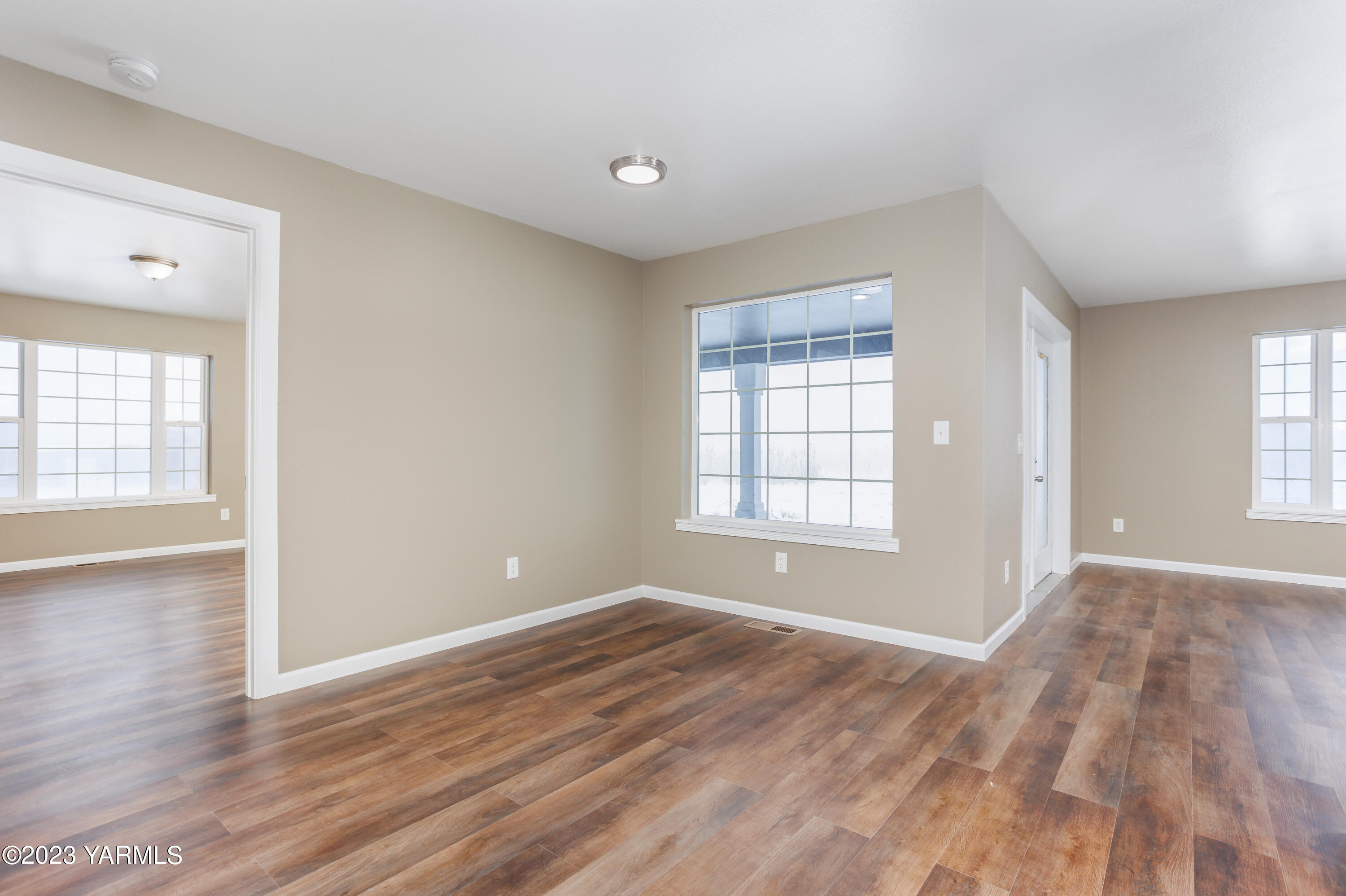 361 Puterbaugh Road Grandview, WA 98930 - Photo 9 of 47 wooden floor in an empty room with a window