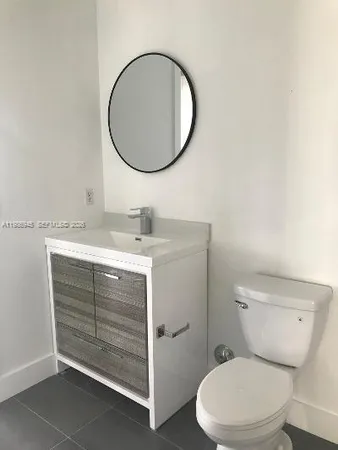a bathroom with a toilet a sink and a mirror