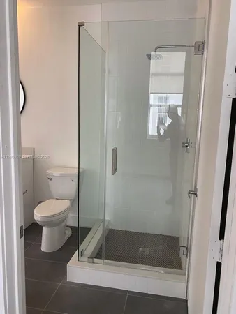 a bathroom with a granite countertop toilet and a shower