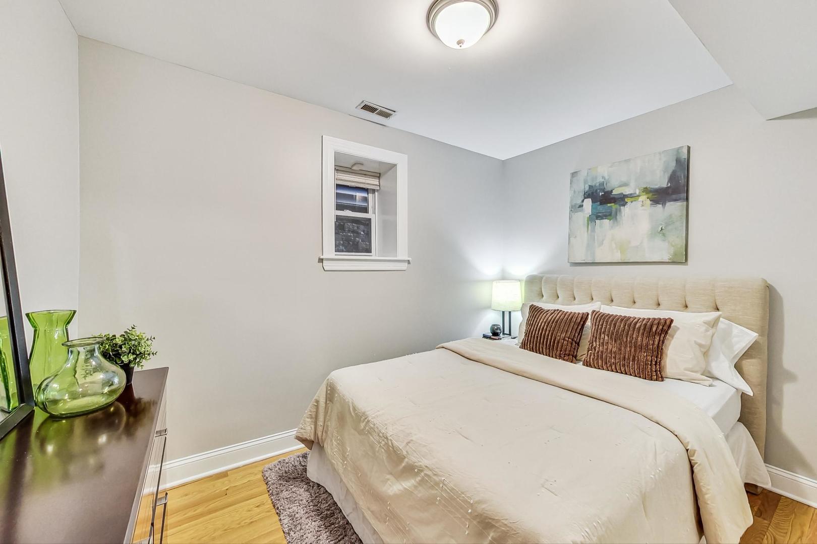 3734 North Clifton Avenue, Unit G Chicago, IL 60613 - Photo 16 of 27 a bedroom with a bed and a potted plant