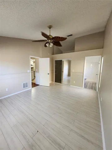 a view of a livingroom with a ceiling fan and wooden floor
