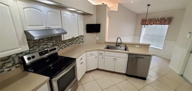 a kitchen with stainless steel appliances a sink dishwasher stove refrigerator and microwave